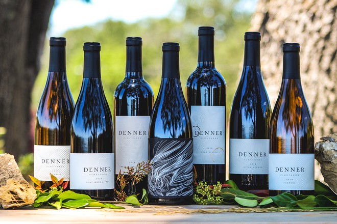 Denner wine bottles lined up in a vineyard.